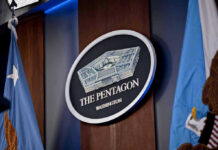 War Powers Showdown – Impeachment Blitz Targets Defense Chief The Pentagon emblem between two flags.