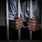 Hanging Homicide Twist—More Arrests Loom person gripping prison bars