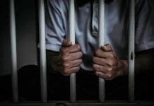 Hanging Homicide Twist—More Arrests Loom person gripping prison bars