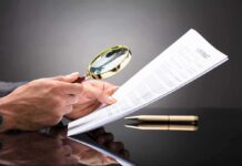 State AG Pounces: Big Tech Immunity Fantasy COLLAPSES Hands holding magnifying glass over contract document