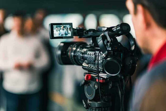 shutterstock_1034456968-2 Video camera filming a group of people