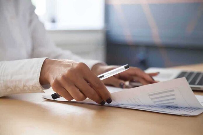 shutterstock_1075420649 Hands reviewing documents at a desk