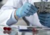 Pritzker’s Slimdown – Costly Meds Hit Taxpayers Gloved hands in a lab coat counting US dollar bills