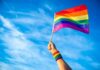 Turkey’s Night Raids – Rights Crackdown Sparks Brussels Fury Hand holding a rainbow pride flag against a blue sky
