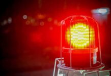 Red emergency warning light with protective cage glowing at night