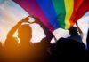 Pride-To-Swastika Image Explodes Online Crowd under a rainbow flag at sunset