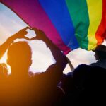Pride-To-Swastika Image Explodes Online Crowd under a rainbow flag at sunset