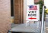 Election Police Banned? Oversight Cut Back Sidewalk sign with American flag directing to a polling place