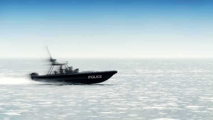 shutterstock_1253930197 Police patrol boat speeding across open water
