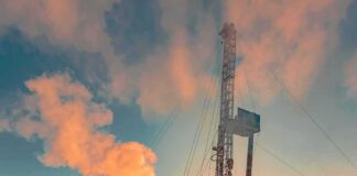 Oil drilling rig at sunset releasing steam