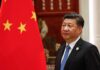 Seven Sites – China’s Nuke Buildout Accelerates Xi Jinping standing beside a Chinese flag