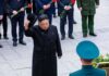Man in black coat tipping hat during formal ceremony