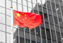 Supersonic Gamble: Beijing’s Year-End Push Chinese flag waving against glass office building