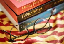 Rowling Wars Hit Broadway Again — Activists Target Grint Round black glasses on striped scarf beside Harry Potter books