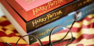 Round black glasses on striped scarf beside Harry Potter books