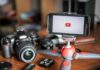 Influencers BANNED: Six Flags Drops HAMMER After Wild Stunt Smartphone on mini tripod beside DSLR camera and lenses