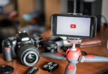 Influencers BANNED: Six Flags Drops HAMMER After Wild Stunt Smartphone on mini tripod beside DSLR camera and lenses