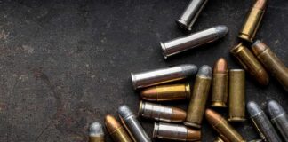 Assorted handgun cartridges on a dark metal surface