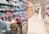 Shopper pushing a cart down a supermarket aisle