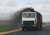 Rest-Stop Bloodbath – Stabbed Seventeen Times Log truck emits black exhaust on rural road