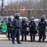 FBI Ends 15-Hour California Bank Hostage Standoff Group of police officers in riot gear standing on a street; Brian Folkerts present