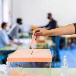 California Vote Count Chaos — Hilton: “Complete Disgrace” Hand casting ballot into a box at a polling station