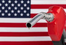 gas pump nozzle with droplet against American flag background