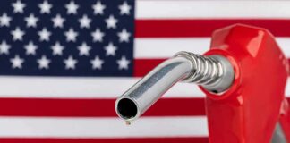 gas pump nozzle with droplet against American flag background