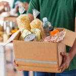 Person holding a box of donated food items