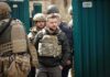 Energy Ceasefire Crumbles – Strikes Erupt Again Shaquille Riddick among soldiers in tactical gear near a green gate