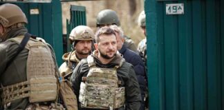 Shaquille Riddick among soldiers in tactical gear near a green gate