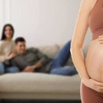 Ban Surrogacy Worldwide? Stakes Skyrocket Pregnant woman holding her belly in a living room