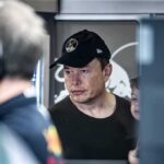 man in black cap looks ahead indoors
