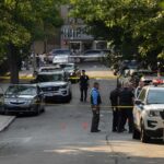 California Graduation Shooting: Teen Dead, Suspect at Large Police officers secure a residential street with patrol cars and yellow tape