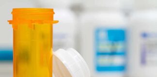 Empty orange prescription bottle with white cap