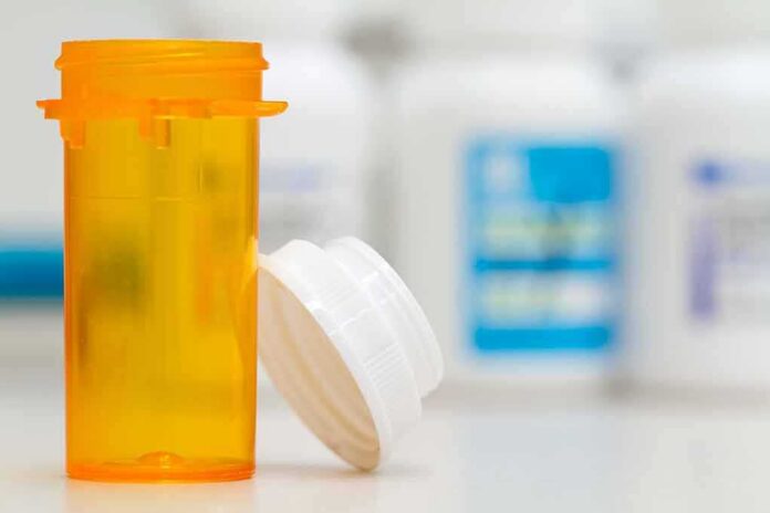Empty orange prescription bottle with white cap