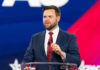 man in suit speaking at a podium