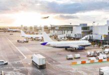 Airport Breach Sparks Ground Shutdown Airplanes at airport gates during sunset with ground vehicles and jet bridges