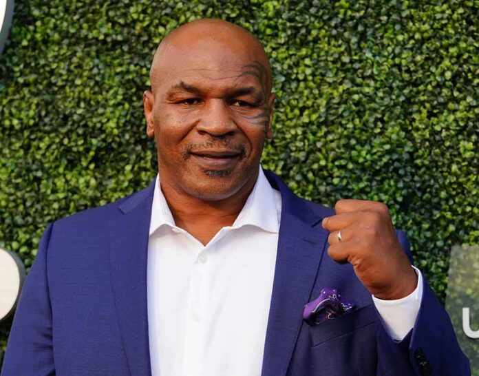 shutterstock_1208743945 Mike Tyson in a blue suit raising a fist