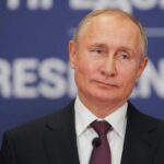 Rome Hospital Dial-In Pressures Putin man in suit speaking at a podium