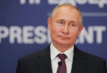 Rome Hospital Dial-In Pressures Putin man in suit speaking at a podium