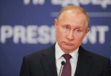 Vladimir Putin at a podium with microphone