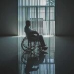 Zurich’s Shocking Mandate Hits Christian Homes Person in a wheelchair silhouetted by a large window