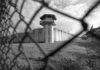 Prison watchtower behind chain-link fence