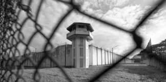 Prison watchtower behind chain-link fence