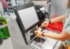 Self-Checkout Vanishes: Goodbye Convenience, Hello Surveillance Shopper scans a bottle at a self-checkout kiosk