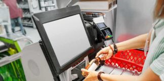 Shopper scans a bottle at a self-checkout kiosk