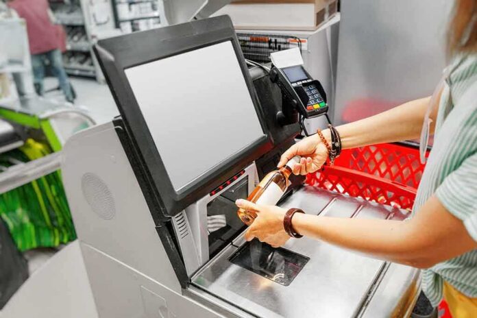 shutterstock_1493463932 Shopper scans a bottle at a self-checkout kiosk