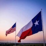 Texas and United States flags waving at sunset