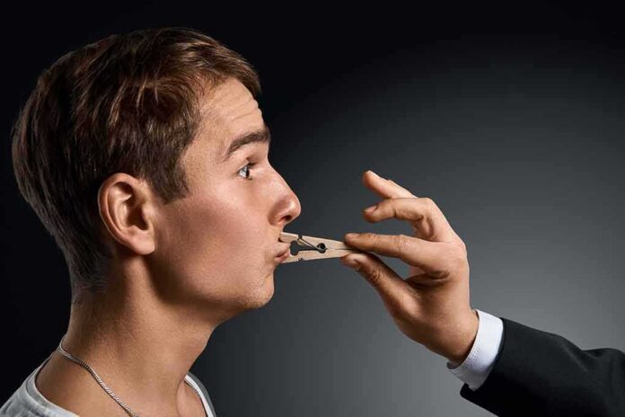 Man in profile with a clothespin on his lips